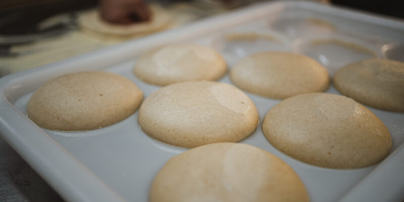 Uncooked pizza dough balls ready to be kneaded and baked.